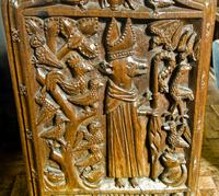 Carved bench end depicting an abbot as a fox