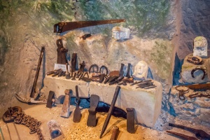 Historic tool display near the cave entrance