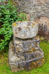 A medieval font bowl outside the church