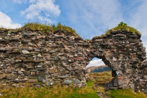 A ruined wall and doorway arch