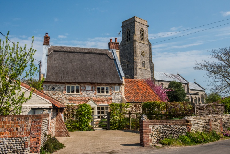 A thatched cottage and St Botolph's Church, Trunch