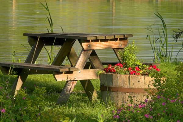 A picnic table beside the River Colne at Bibury, Gloucestershire