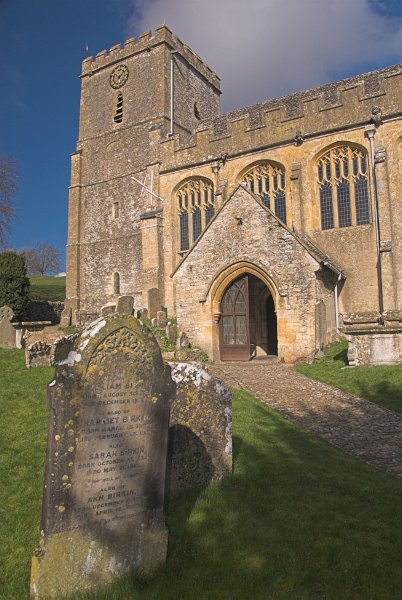 Another view of the churchyard and south porch of St Andrew's. The tower dates to the year 1100. Photo of St Andrew's Church, Chedworth, Gloucestershire.