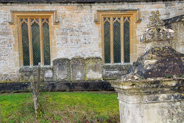 Churchyard table tomb and exterior of the north aisle. Photo of St Mary's Church, Great Barrington, Gloucestershire.