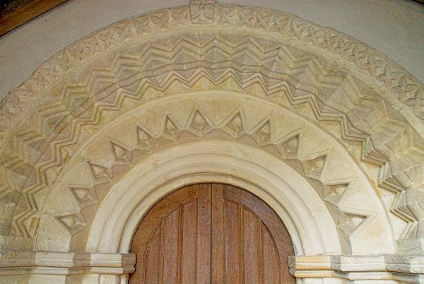 View of the layered decoration of the Norman arch at the south door of St Peter's Church. Photo of Little Barrington, Gloucestershire. Part of the Britain Express travel and heritage picture library.