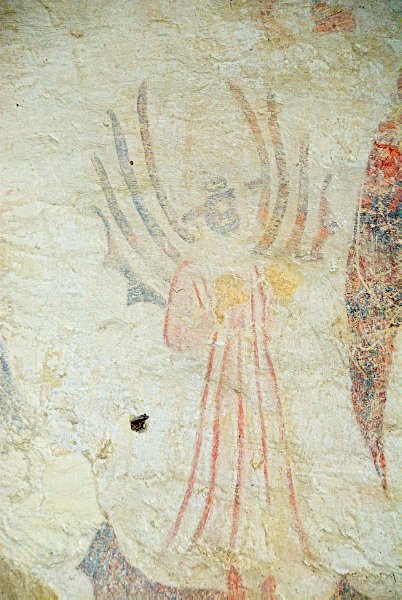 This winged figure stands to the left of Cardinal Wolsey in the 'Magnificence' mural. Photo of St Nicholas' Church, Lower Oddington, Gloucestershire. Part of the Britain Express historic picture library.