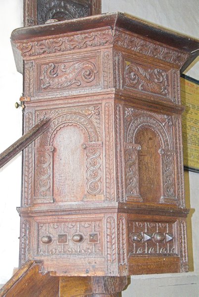 The pulpit is situated against the north wall of the nave. Its a beautifully carved affair, with a holder for a candle set into the wall just above it. Photo of St Nicholas' Church, Lower Oddington, in the Gloucestershire Cotswolds. Part of the Britain Express Travel and Heritage Picture Library.