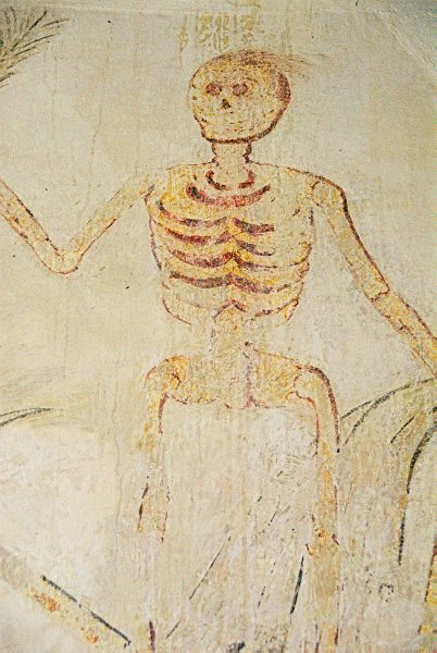 Above the tower arch is this striking medieval wall painting depicting a skeleton gripping an arrow. Photo of All Saints Church, Salperton, in the Gloucestershire Cotswolds. Part of the Britain Express Travel and Heritage Picture Library.