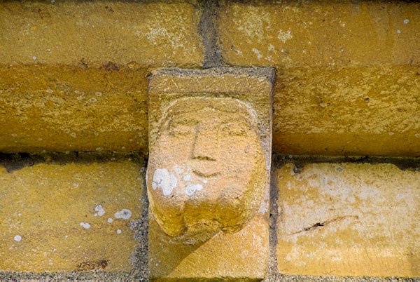A happy, even blissful, carved head. (or is it just self-satisfied?) Photo of St Mary's Church, Temple Guiting, in the Gloucestershire Cotswolds. Part of the Britain Express Travel and Heritage Picture Library.