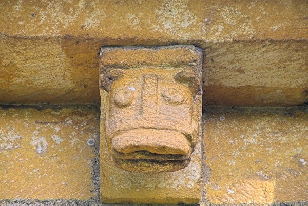 The carved head of a beast in the corbel table. Photo of St Mary's Church, Temple Guiting, in the Gloucestershire Cotswolds. Part of the Britain Express Travel and Heritage Picture Library.
