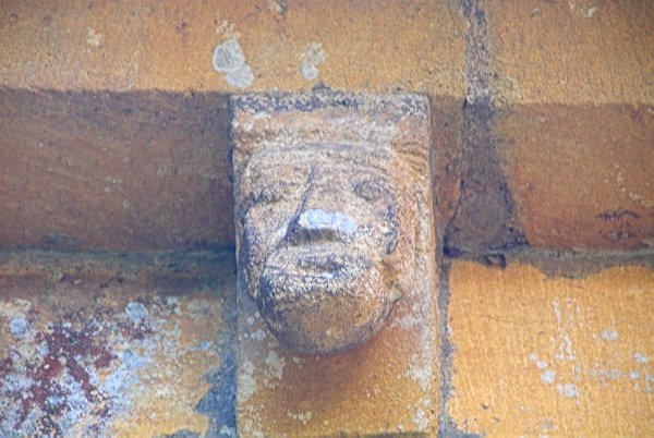 A man's head on the corbel table. Photo of St Mary's Church, Temple Guiting, in the Gloucestershire Cotswolds. Part of the Britain Express Travel and Heritage Picture Library.
