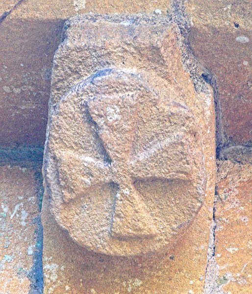 The only corbel head not depicting a human or beast. This cross is of a style often called a 'Templar Cross', perhaps an indication of the church's connection with the Knights Templar in the 12th century. Photo of St Mary's Church, Temple Guiting, Gloucestershire. Part of the Britain Express Historic Picture Library.
