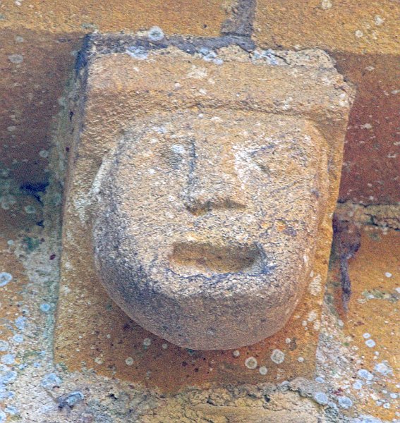 A cheerful laughing face. Photo of a corbel head on St Mary's Church, Temple Guiting, in the Gloucestershire Cotswolds. Part of the Britain Express Travel and Heritage Picture Library.
