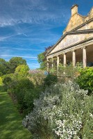 Formal lawns lined by flower beds lead past the manor to a secluded fountain