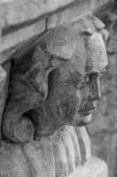 Carved head on font