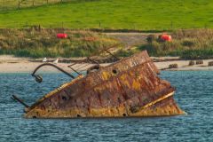 A rusted blocking ship sunk offshore