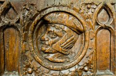 Carved head of a man on a bench end in the nave
