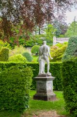 A classical statue and hedges