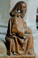 Seated figure arm-rest carving