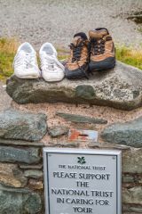 Walking boots left behind to on a stone gatepost
