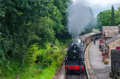A steam locomotive pulling into Haworth station