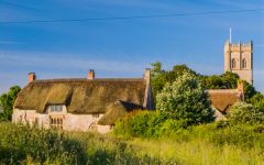 The cottage with the church beyond