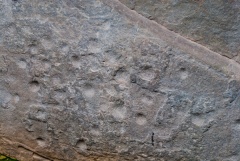 Cupmarks and axehead carvings on the capstone