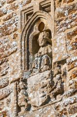 Carved figure on the tower holding an heraldic shield