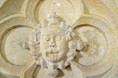 Carved head on the font