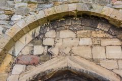 A blocked Romanesque arch with a pointed arch beneath