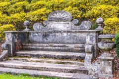 An ornate garden seat looking towards the koi pond