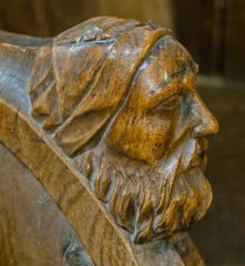 Man's head on a choir stall