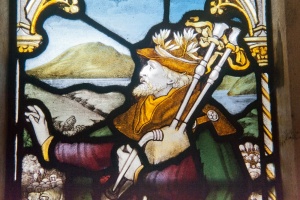 CE Kempe stained glass of a bagpiper