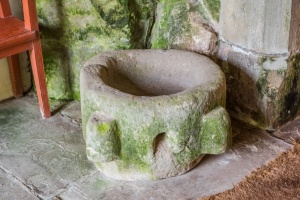 A worn medieval font in the porch