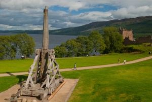 A reconstructed trebuchet stands above the castle