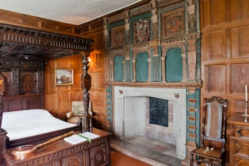 A panelled bedchamber and four-poster bed