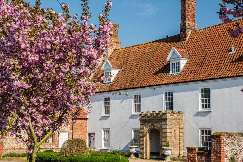 A whitewashed house opposite Binham's village green