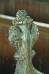 A worn poppyhead bench end