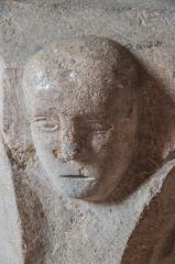 Carved head on the font