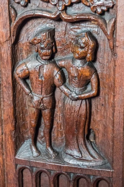 A couple 'handfasting' carved bench end