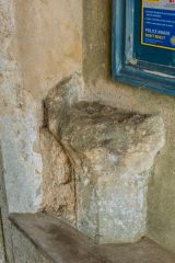 A worn holy water stoup beside the south door