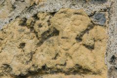 Carved head of a bishop set into the wall