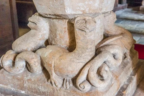 13th-century dragon carving on the font base