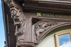 A caryatid supports the overhanging first floor
