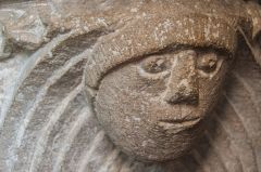 Carved head on the font