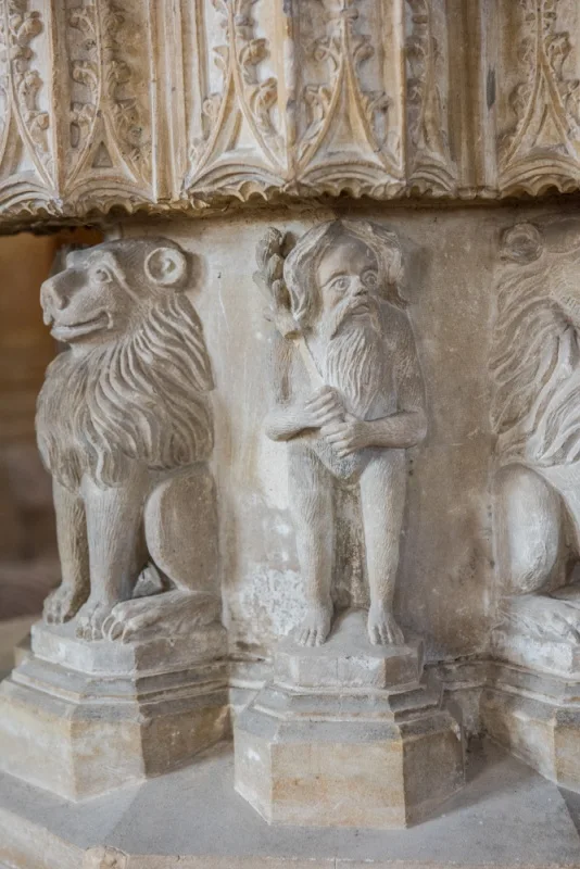 A woodwose and lions on the font base