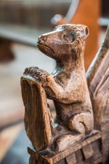 Bench end of a bear holding a shield