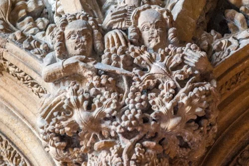 Carving of two men cutting grapes