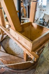 Hopper feding grain to the grindstones