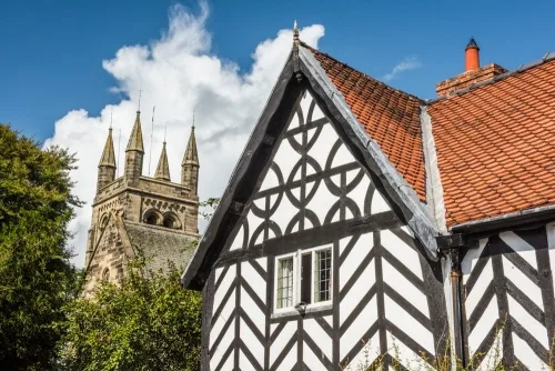All Saints Church tower and a timber-framed building